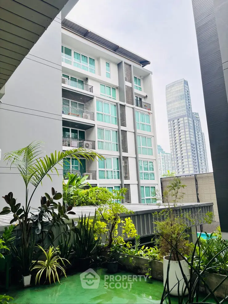 Modern urban apartment building with lush green balcony view