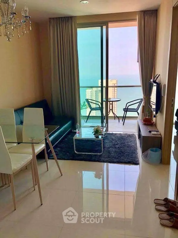 Chic living room with ocean view balcony, modern furniture, and elegant decor.