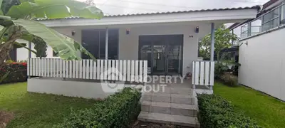 Charming single-story house with inviting front porch and lush garden
