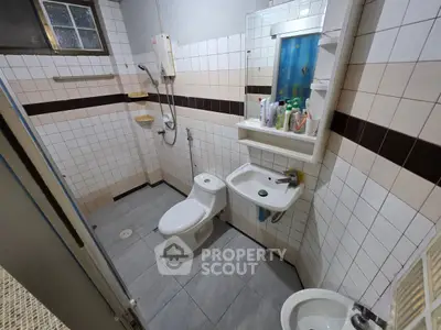 Compact bathroom with tiled walls, modern fixtures, and essential amenities.