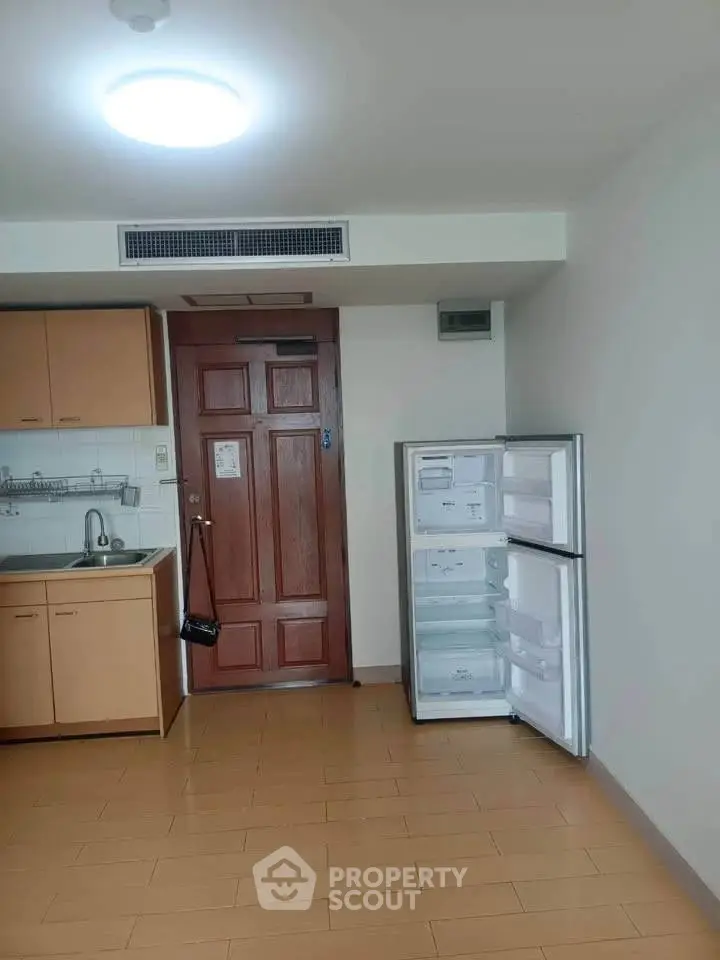 Compact kitchen with fridge in cozy apartment
