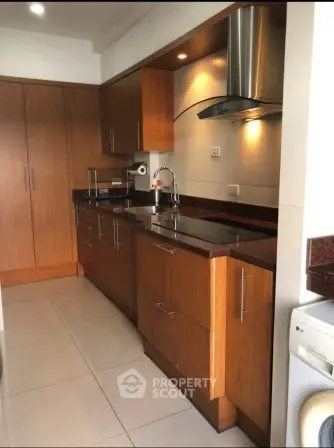 Modern kitchen with wooden cabinets and sleek appliances in a stylish apartment.