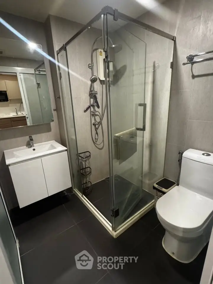 Modern bathroom with glass shower enclosure and sleek fixtures