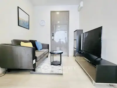 Modern living room with sleek furniture and large TV, perfect for relaxation.