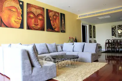 Spacious living room with modern decor and plush seating, featuring artistic wall paintings and elegant dining area.