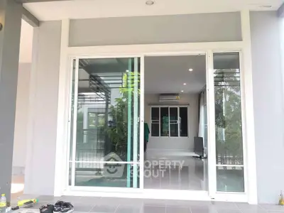 Modern home with sliding glass doors opening to a spacious living area, featuring sleek design and ample natural light.
