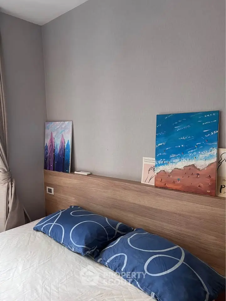 Cozy bedroom with modern decor and abstract art on headboard, featuring plush pillows and soft lighting.