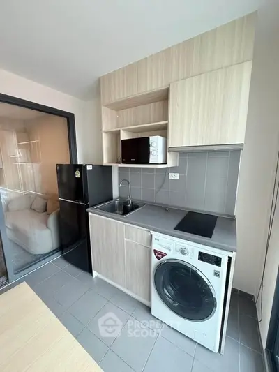 Modern kitchen with sleek appliances and ample storage in a stylish apartment.