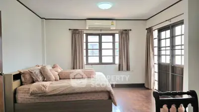 Spacious bedroom with natural light and balcony access in modern home.
