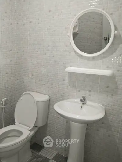 Modern bathroom with sleek white fixtures and elegant tiled walls.