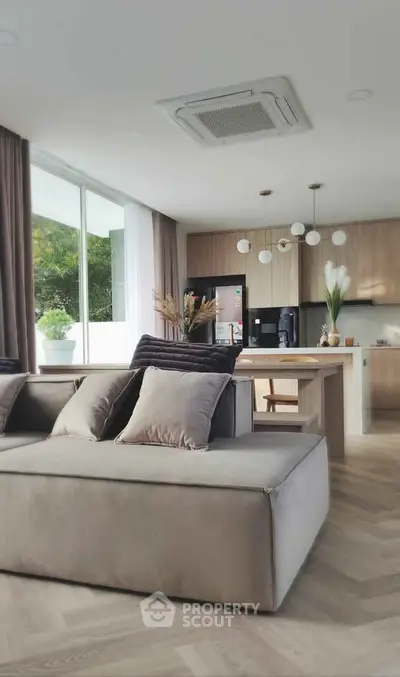 Modern open-layout living room and kitchen with stylish decor and natural light