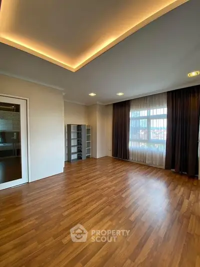 Spacious living room with elegant wooden flooring and modern ceiling lighting