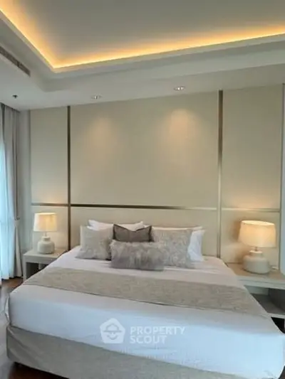 Luxurious bedroom with elegant lighting and plush bedding in a modern apartment.