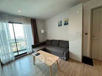 Modern living room with large window and stylish furniture, offering a cozy and inviting atmosphere.