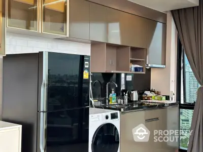 Modern kitchen with sleek cabinets, washing machine, and city view window.