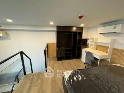 Modern loft-style bedroom with study area and sleek wooden flooring