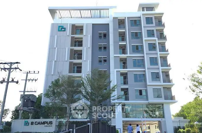 Modern multi-story building with sleek design and large windows in urban setting.