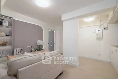 Modern living room with neutral tones and stylish decor, featuring a cozy sofa and built-in shelving.