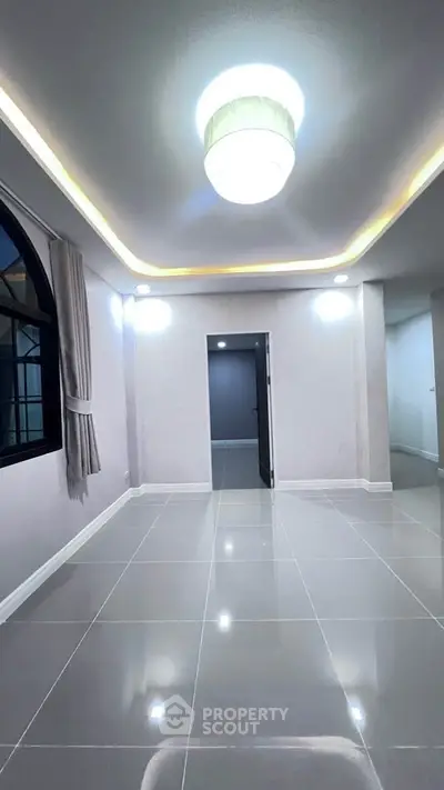 Spacious modern living room with elegant lighting and large window, perfect for stylish urban living.