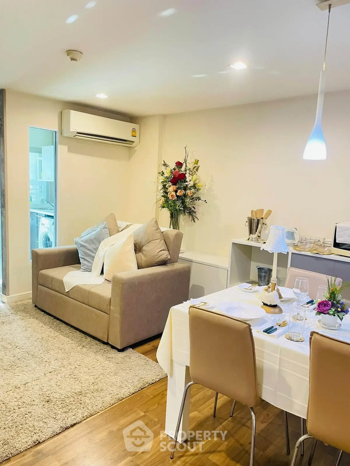 Cozy living room with dining area, featuring modern decor and air conditioning.