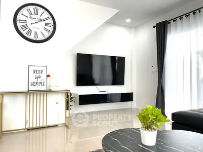 Modern living room with sleek decor, wall-mounted TV, and stylish clock.