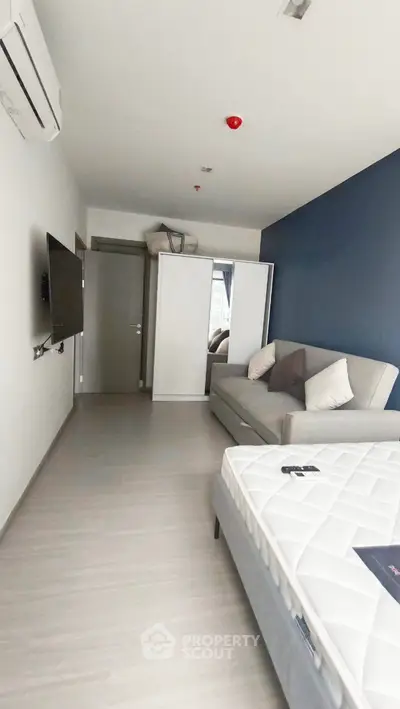 Modern bedroom with sleek design, featuring a comfortable bed, stylish sofa, and wall-mounted TV for ultimate relaxation.