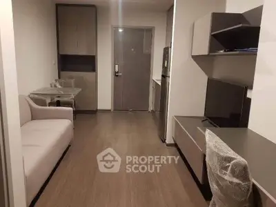 Modern living room with sleek furniture and TV setup in a cozy apartment.