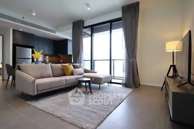 Modern living room with sleek furniture and open kitchen layout in a stylish apartment.