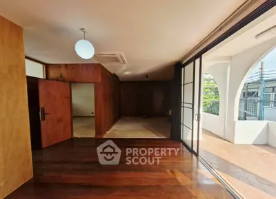 Spacious living room with wooden floors and large balcony access