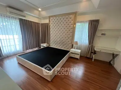 Spacious bedroom with elegant tufted headboard and natural light