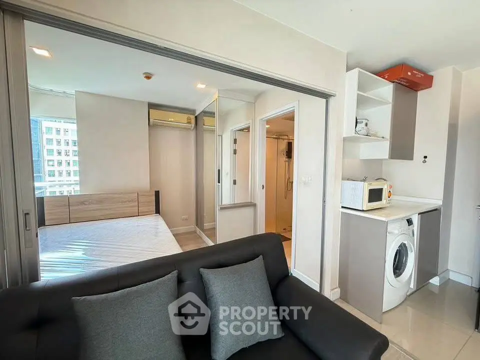 Modern studio apartment with sleek design, featuring a cozy living area, compact kitchen, and bright bedroom.