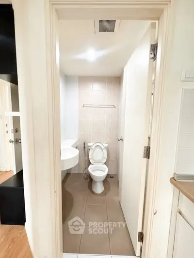 Compact bathroom with modern fixtures and neutral tiles, ideal for urban living spaces.