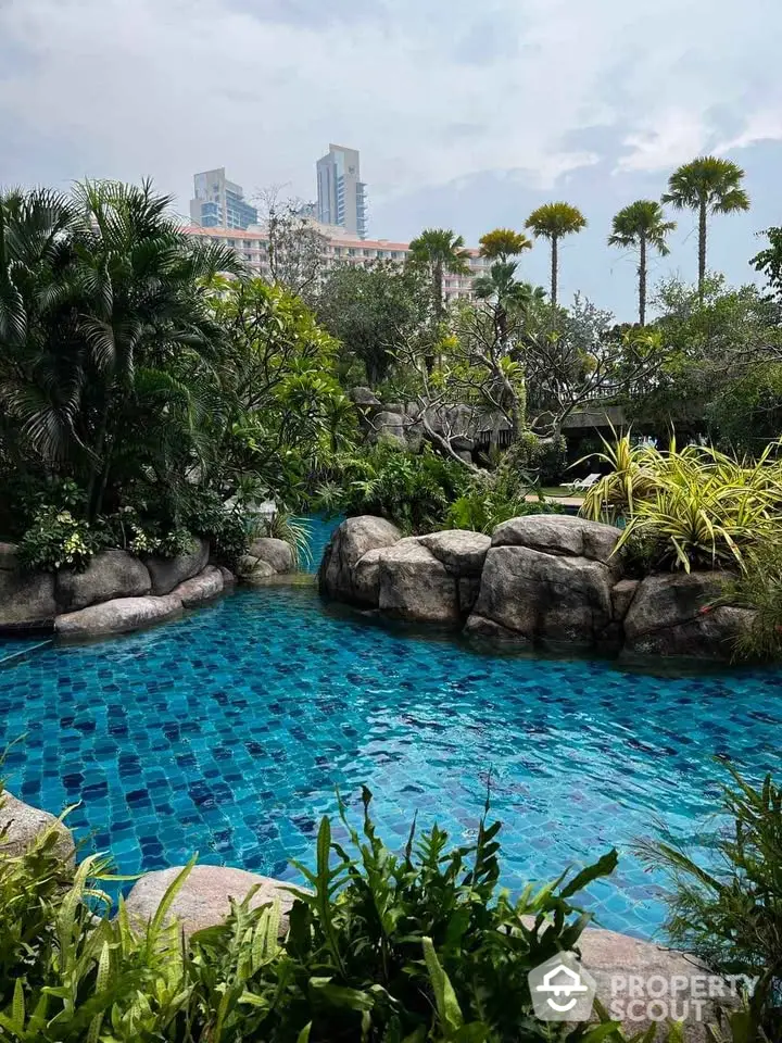 Luxurious tropical pool with lush greenery and city skyline view