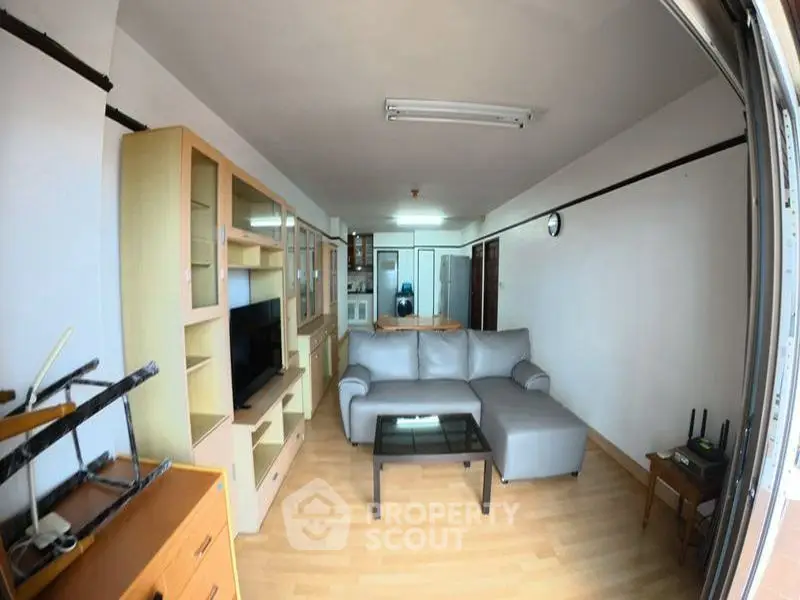 Spacious living room with modern furniture and wooden flooring, ideal for relaxation and entertainment.