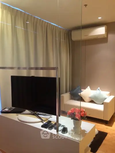 Modern living room with sleek TV setup and cozy seating area, perfect for relaxation.