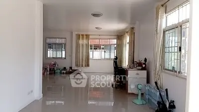 Spacious open-plan living area with large windows and glossy tiled floors.