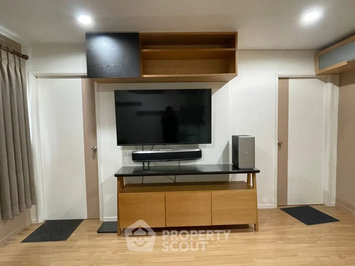 Modern living room with sleek wooden TV stand and mounted flat-screen TV