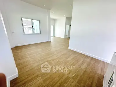 Spacious modern interior with wooden flooring and bright natural light, perfect for versatile living space.