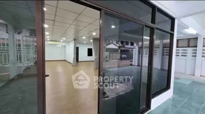 Spacious modern interior with glass doors and wooden flooring, ideal for versatile living or office space.