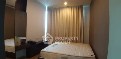 Cozy bedroom with large window and modern furnishings, perfect for relaxation and comfort.