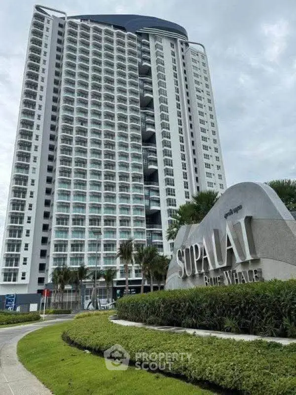Modern high-rise building with lush landscaping at Supalai Blue Whale.