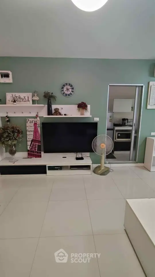 Modern living room with sleek TV setup and open kitchen view