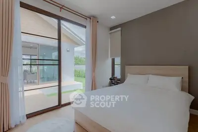 Modern bedroom with large windows and access to spacious balcony in luxury home.
