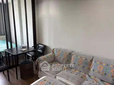 Cozy living room with floral sofa and dining area in modern apartment