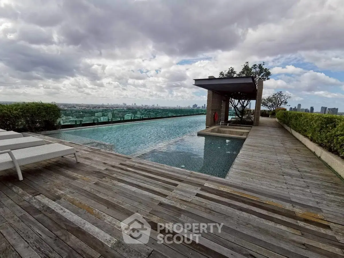 Luxurious rooftop pool with stunning city skyline views and wooden deck.
