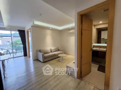 Modern living room with balcony access and adjacent bathroom, featuring sleek wooden flooring and contemporary design.
