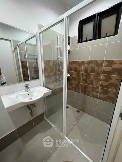 Modern bathroom with glass shower enclosure and stylish tile design.