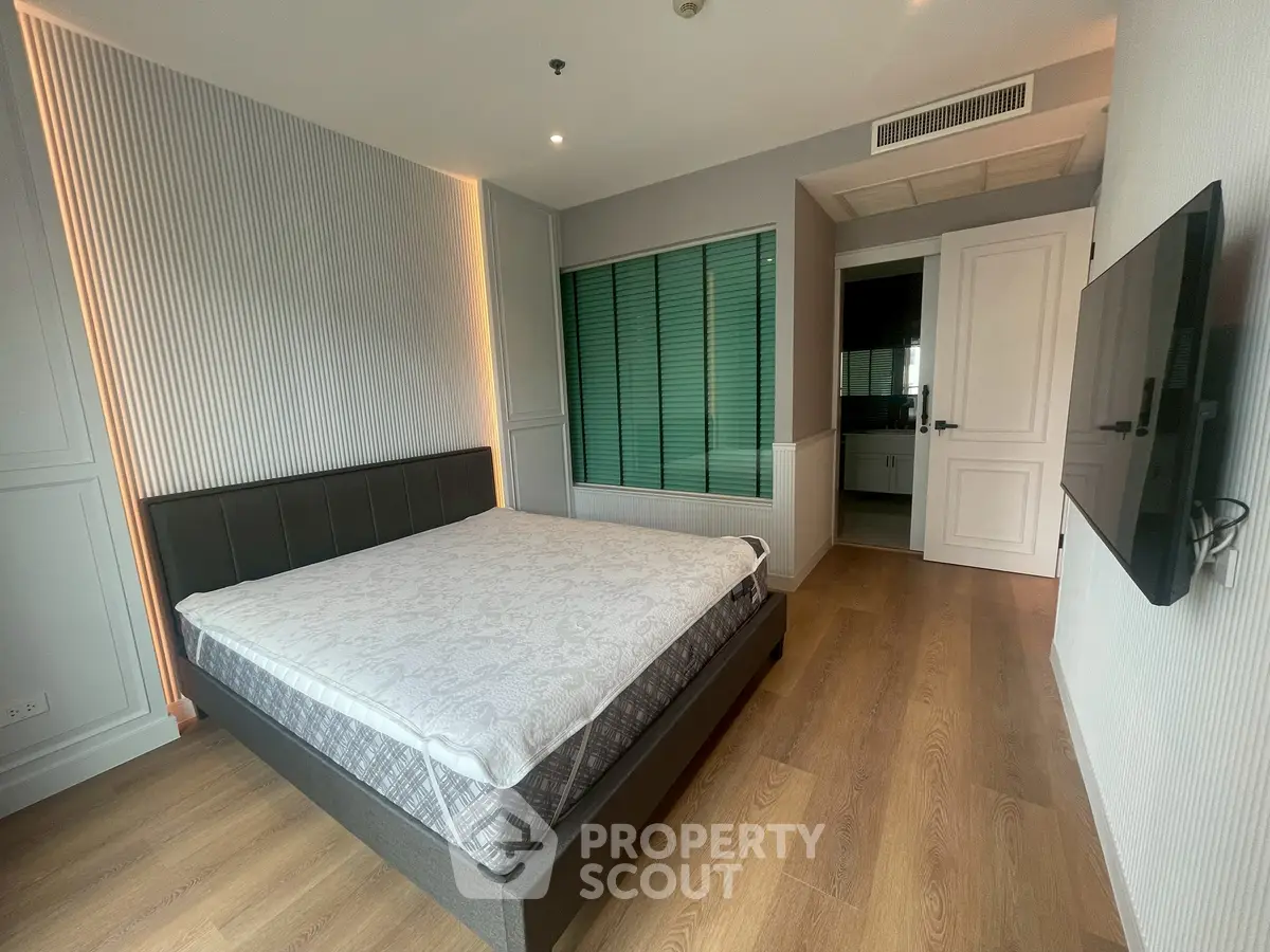 Modern bedroom with stylish decor and ensuite bathroom in a luxury apartment.