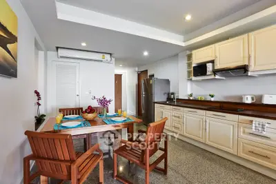 Spacious kitchen with dining area, featuring modern appliances and elegant wooden furniture.