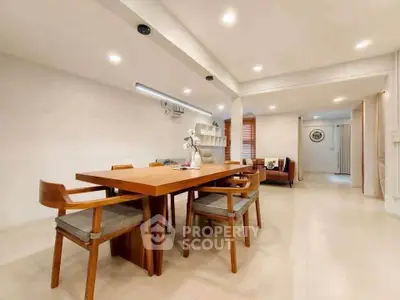 Spacious modern dining area with elegant wooden table and chairs, perfect for family gatherings.